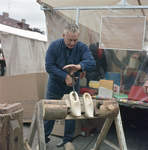831114 Afbeelding van een klompenmaker tijdens een demonstratie oude ambachten op de jaarmarkt in Cothen die werd ...